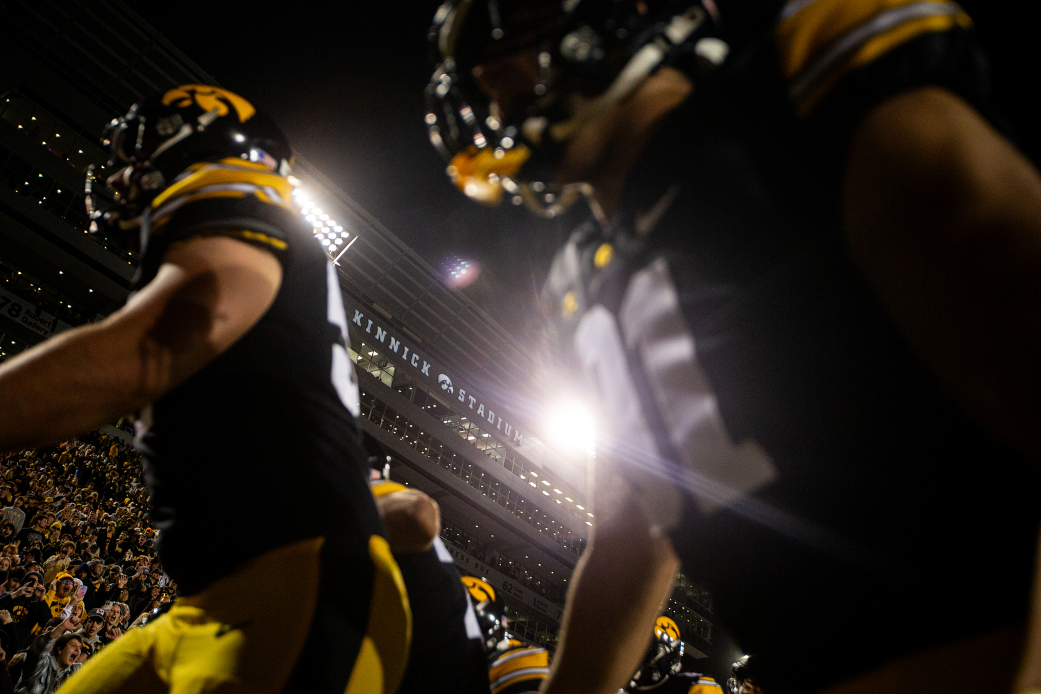 Two football players in a full stadium at night